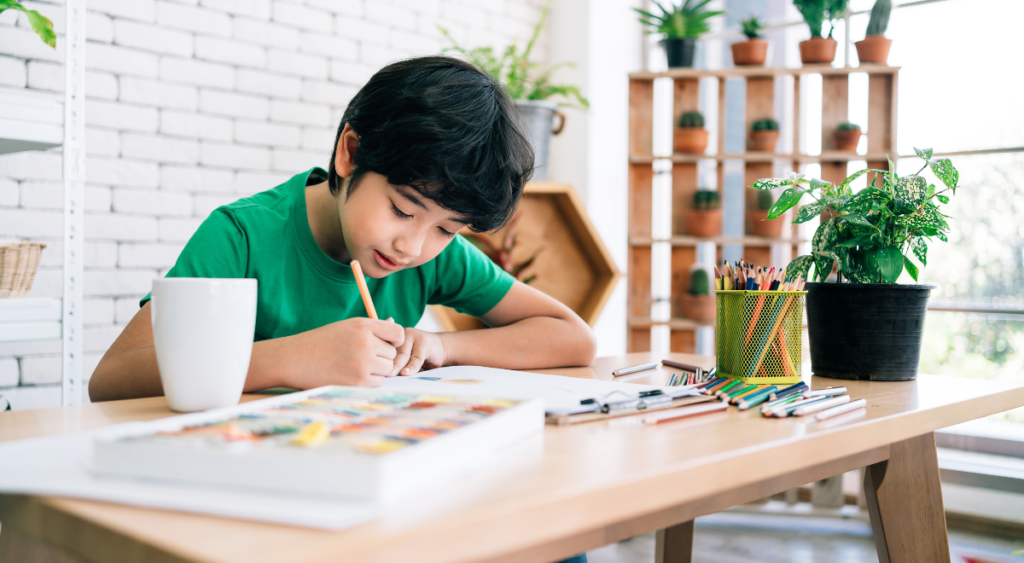 Young learner draws with colored pencils at desk