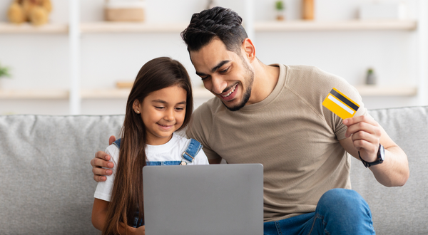 parent and child with credit card at laptop